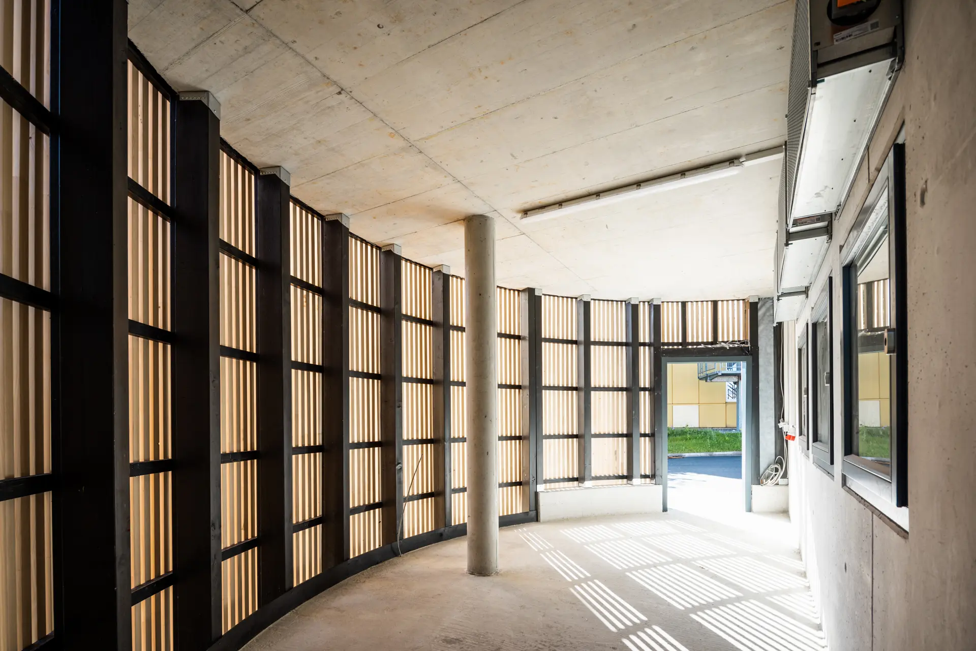 Neubau Heizzentrale in Ravensburg mit Sichtbetonfassade und vertikaler Weißtannen-Leistenschalung